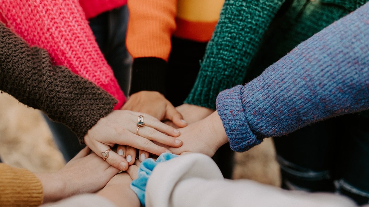 girl friends hands piled togethger